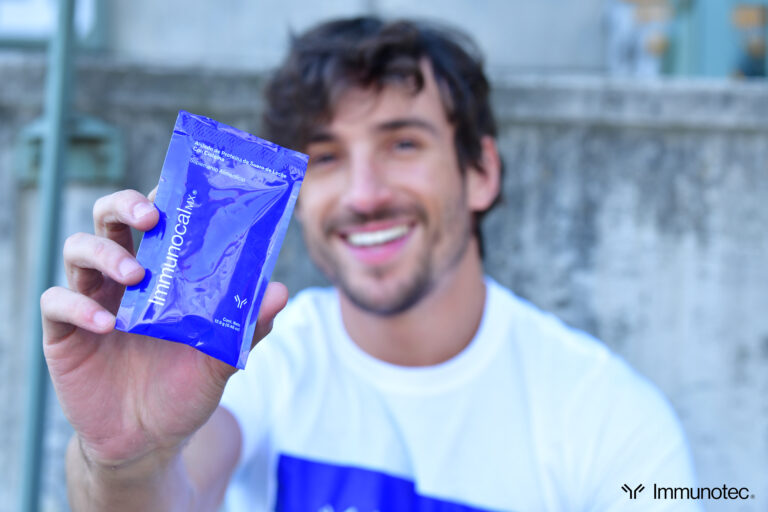 Hombre sosteniendo un sobre de Immunocal MX, suplemento natural para fortalecer el sistema inmunológico.